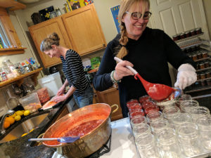 Filling jars with roasted strawberry preserves.